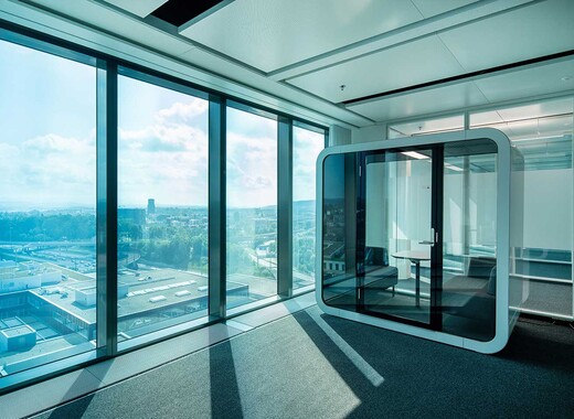 Office interior with smart glass windows looking over view of the city. 