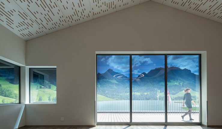 View from inside a modern room with tinted glass windows looking outside at nature.