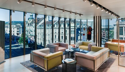 Interior of lounge with floor to ceiling smart glass windows overlooking the city.
