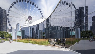 Building facade with smart windows from left to right on a large modern glass building with a shot of ferris wheel.