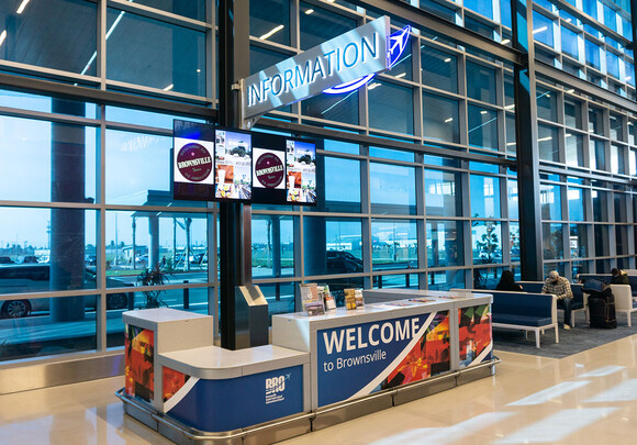 Interior of airport information desk with custom smart glass windows from left to right. 