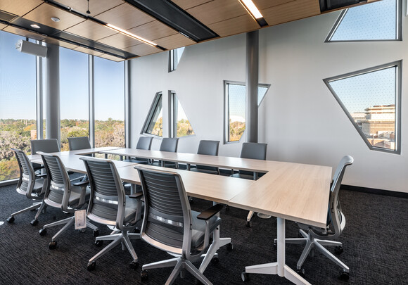 Trapezoidal electrochromic windows provide glare control in conference room.