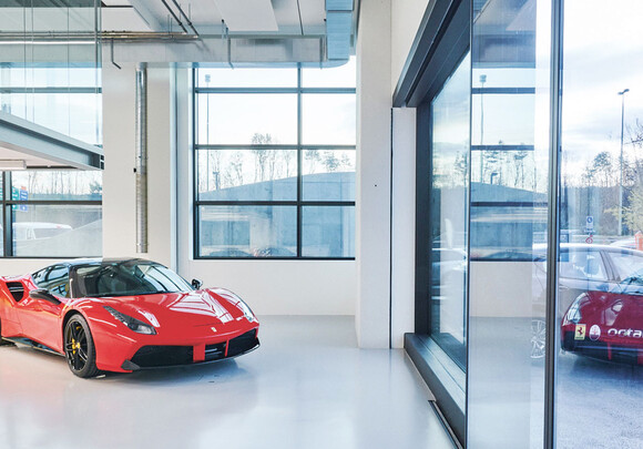 Building interior of garage with smart glass windows and a ferrari. 